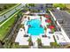 Aerial view of community pool with sunshades, lounge area and nearby parking at 17093 Moonflower Dr, Venice, FL 34293