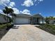 Charming single-story home featuring a paver driveway, two car garage, and covered front porch at 17093 Moonflower Dr, Venice, FL 34293