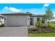 Beautiful one-story home with a two-car garage, neutral colors and appealing landscaping on a sunny day at 17093 Moonflower Dr, Venice, FL 34293