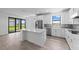 A modern kitchen featuring stainless steel appliances, white cabinets, and an island with seating at 17093 Moonflower Dr, Venice, FL 34293
