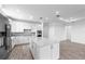 Spacious kitchen featuring stainless steel appliances, white cabinets, and an island with seating at 17093 Moonflower Dr, Venice, FL 34293