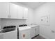 Functional laundry room features a sink, cabinets, and modern washer and dryer at 17093 Moonflower Dr, Venice, FL 34293