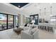 Bright living room with sliding glass doors, modern decor, and seamless flow to the kitchen at 17093 Moonflower Dr, Venice, FL 34293
