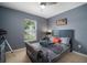 Comfortable bedroom with blue walls, a well-dressed queen bed, and a window offering natural light at 17413 Garden Heath Ct, Land O Lakes, FL 34638