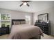 Neutral bedroom with a queen-size bed, dark wood furniture, and natural light from two windows at 17413 Garden Heath Ct, Land O Lakes, FL 34638