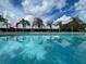 A refreshing community pool surrounded by palm trees offers a relaxing oasis at 17413 Garden Heath Ct, Land O Lakes, FL 34638