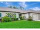 Well maintained single-story home with a lush green lawn and an attached two-car garage at 18807 Tournament Trl, Tampa, FL 33647