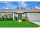 Beautiful home featuring a lush green lawn and inviting curb appeal with charming green shutters at 18807 Tournament Trl, Tampa, FL 33647