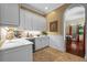 Elegant butler's pantry featuring white cabinetry, stone counters, wine rack, and wine fridge; arched entryway to dining room at 1915 Floresta View Dr, Tampa, FL 33618
