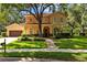 Stunning two-story home featuring a red tile roof, lush landscaping, and an inviting arched entryway at 1915 Floresta View Dr, Tampa, FL 33618