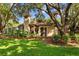 Lush landscaping and mature trees surround this home's exterior, complete with a backyard and a fire pit at 1915 Floresta View Dr, Tampa, FL 33618