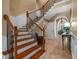 Grand foyer with staircase featuring oak treads, iron balusters, travertine tile flooring and access to dining room at 1915 Floresta View Dr, Tampa, FL 33618