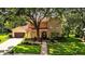 Charming two-story home with a red tile roof, arched entryway, and lush landscaping at 1915 Floresta View Dr, Tampa, FL 33618