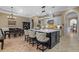 Chef's kitchen featuring a large island with seating, stone counters, and views of dining and living spaces at 1915 Floresta View Dr, Tampa, FL 33618