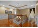 Landing area with wood floors, neutral paint, modern lighting, and railing overlooking the staircase at 1915 Floresta View Dr, Tampa, FL 33618