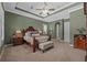 This spacious main bedroom showcases a tray ceiling, ceiling fan, a window with plantation shutters, and green walls at 1915 Floresta View Dr, Tampa, FL 33618