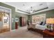 Main bedroom features tray ceiling, a ceiling fan, an area rug, and views of the lush landscape at 1915 Floresta View Dr, Tampa, FL 33618