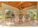Outdoor kitchen with a built-in bar, stainless steel hood, countertop seating and tiled flooring at 1915 Floresta View Dr, Tampa, FL 33618