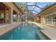 Beautiful screened-in swimming pool, connecting to outdoor seating area and luxurious backyard at 1915 Floresta View Dr, Tampa, FL 33618