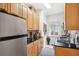 Galley kitchen with wooden cabinets, granite countertops, and stainless steel appliances and a sunlit window at 2117 W Dekle Ave # D1, Tampa, FL 33606