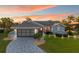 Charming blue single-story home with a red front door, manicured lawn, and a patterned concrete driveway at 220 Singapore Rd, Punta Gorda, FL 33950