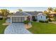 Well-maintained blue single-story home with a red front door, manicured lawn, and a patterned concrete driveway at 220 Singapore Rd, Punta Gorda, FL 33950