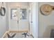 Bright foyer featuring a decorative front door with glass panels, and a starfish rug over light hardwood flooring at 220 Singapore Rd, Punta Gorda, FL 33950