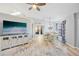 Open-concept living area with a large television, dining table, and hardwood floors creating an inviting space at 220 Singapore Rd, Punta Gorda, FL 33950