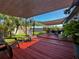 Spacious back patio with a shade sail, comfortable seating, and a view of the lush backyard at 2400 62Nd N St, St Petersburg, FL 33710