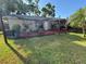 Cozy backyard featuring a red deck, charming patio furniture, lush lawn, and string lights at 2400 62Nd N St, St Petersburg, FL 33710