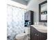 Compact bathroom with a modern vanity, patterned shower curtain, and neutral color scheme at 2400 62Nd N St, St Petersburg, FL 33710