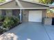 Inviting single-story home featuring a tidy front yard, blue door, and a convenient attached garage at 2400 62Nd N St, St Petersburg, FL 33710
