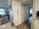 Hallway with closet and storage areas, neutral walls, and wood-look floors connecting living spaces at 2400 62Nd N St, St Petersburg, FL 33710