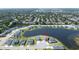 Aerial view of lake community with many homes on manicured lawns and mature landscaping at 2563 Ocean Breeze Ln, Clearwater, FL 33761