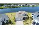 Aerial view of house near lake with manicured lawn, landscape, and a paver driveway at 2563 Ocean Breeze Ln, Clearwater, FL 33761