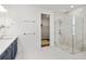 Bright bathroom featuring a glass shower, double shower heads, marble floors and walk-in closet at 2563 Ocean Breeze Ln, Clearwater, FL 33761