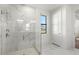 Modern bathroom featuring a frameless glass shower, marble floors, and a window with a view at 2563 Ocean Breeze Ln, Clearwater, FL 33761