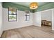 Stylish bedroom featuring wood floors, modern lighting, and two windows at 2563 Ocean Breeze Ln, Clearwater, FL 33761
