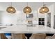 Beautiful kitchen with white cabinetry, quartz countertops, and woven pendant lighting over the island at 2563 Ocean Breeze Ln, Clearwater, FL 33761