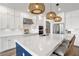 Gorgeous kitchen showcasing white cabinets, quartz countertops, a stylish blue island, and pendant lighting at 2563 Ocean Breeze Ln, Clearwater, FL 33761
