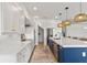 Bright kitchen featuring white cabinets, quartz countertops, stainless steel appliances, and stylish pendant lighting at 2563 Ocean Breeze Ln, Clearwater, FL 33761