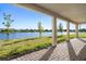 Covered patio area with brick pavers overlooking a serene lake view, perfect for outdoor relaxation at 2563 Ocean Breeze Ln, Clearwater, FL 33761