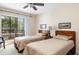 Cozy bedroom featuring two beds, a ceiling fan, and access to a balcony at 2595 Countryside Blvd # 8205, Clearwater, FL 33761