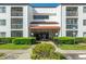 Well-maintained condominium entrance with glass doors, manicured landscaping, and visible accessibility signage at 2595 Countryside Blvd # 8205, Clearwater, FL 33761