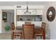 A dining room with a wood table and chairs, with seating for four, adjacent to the living area and kitchen at 2595 Countryside Blvd # 8205, Clearwater, FL 33761