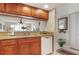 Kitchen featuring wooden cabinets, granite countertops, and a passthrough window to the living area at 2595 Countryside Blvd # 8205, Clearwater, FL 33761