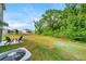 Spacious backyard with two chairs on the patio and surrounded by lush green trees at 32775 Brooks Hawk Ln, Wesley Chapel, FL 33543