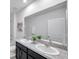 Bathroom featuring a double vanity with granite countertops and a large mirror at 32775 Brooks Hawk Ln, Wesley Chapel, FL 33543