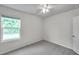 Neutral bedroom featuring a window, ceiling fan and carpeted floors at 32775 Brooks Hawk Ln, Wesley Chapel, FL 33543