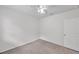 This bedroom features neutral carpet, a ceiling fan, and a door at 32775 Brooks Hawk Ln, Wesley Chapel, FL 33543